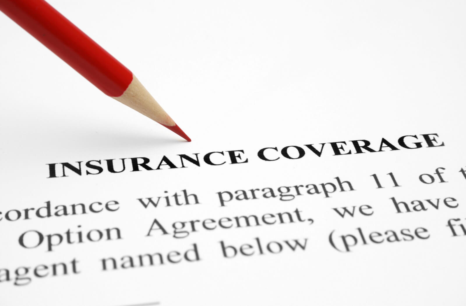 Close-up page of an insurance coverage and a red pencil in the background.