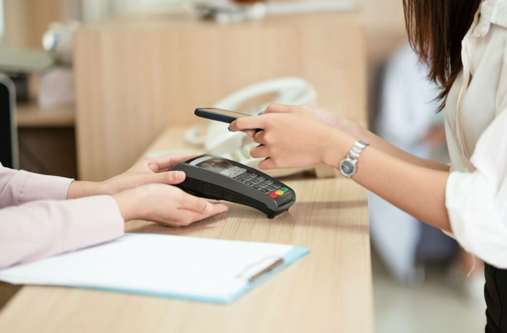 An image of someone paying for the portion of their eye exam bill that wasn't covered by insurance.